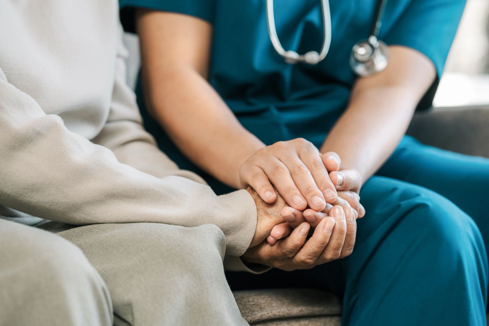 Illustration of a caregiver gently holding an older adult’s hands